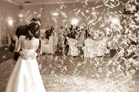 Bride and Groom having first dance showered in Confetti